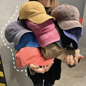 Puede incluir: Una colecci&oacute;n de ocho gorras de b&eacute;isbol en varios colores, incluyendo rojo, azul, marr&oacute;n, beige y gris. Las gorras est&aacute;n hechas de una tela de algod&oacute;n suave y tienen un estilo cl&aacute;sico y casual.