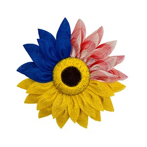May include: A yellow sunflower wreath with blue and pink burlap accents. The sunflower has a brown center and the petals are made of burlap.