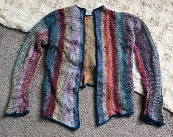 May include: A long-sleeved open-front cardigan featuring a multi-coloured vertical striped pattern in shades of blue, purple, red, yellow, and green. The garment is constructed with a textured knit stitch and finished with a solid dark teal trim.