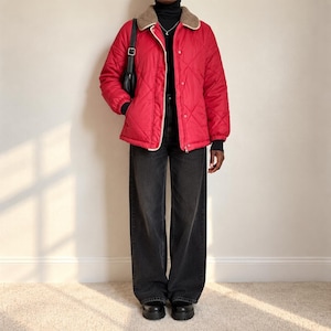 May include: A bright red quilted jacket with a tan faux-fur collar, snap-button closure, and long sleeves. The jacket is worn over a black turtleneck sweater and paired with loose-fitting black denim jeans and black platform boots.