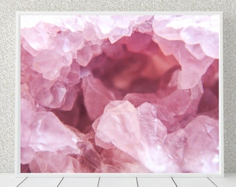 May include: Close-up of a pink crystal geode with a hollow center. The crystal is made up of many small, pointed crystals that are clustered together.