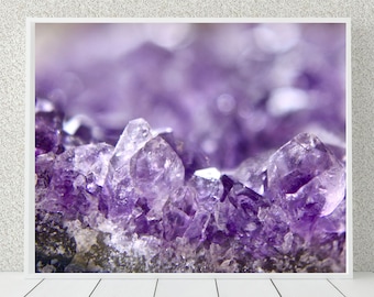 May include: Close-up of a cluster of amethyst crystals, showcasing their deep purple color and intricate formations. The crystals are illuminated by a soft light, highlighting their translucent nature.