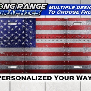 May include: A distressed American flag license plate with rivets. The license plate is red, white, and blue with a faded look. The text "LONG RANGE GRAPHICS" and "MULTIPLE DESIGNS TO CHOOSE FROM!" is at the top of the image. The text "PERSONALIZED YOUR WAY!" is at the bottom of the image.