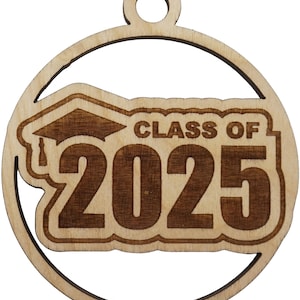 May include: A wooden ornament with a graduation cap design and the text "CLASS OF 2025" engraved in a circular frame. The ornament is made of light-colored wood with a darker engraved design.
