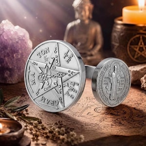 Może przedstawiać: Srebrzysta metalowa bransoletka z dwoma okrągłymi medalionami. Większy medalion przedstawia pentagram z wygrawerowanym napisem "TETRAGRAMMATON", a mniejszy medalion ukazuje postać w szacie trzymającą laskę.