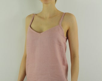 Pode incluir: Uma blusa rosa claro sem mangas com decote em V. A blusa é feita de um tecido macio e texturizado.