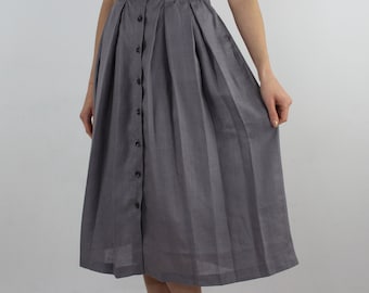 May include: A gray midi skirt with a button-up front and pleats. The skirt is made of a lightweight fabric.