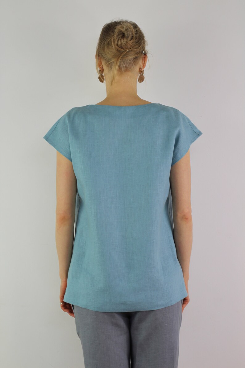 May include: A light blue linen top with short sleeves and a scoop neck.