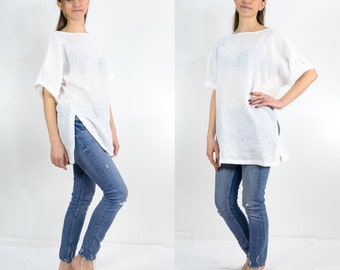 May include: A white linen tunic top with a relaxed fit and side slits. The top is shown with blue jeans.