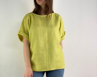 May include: A light yellow linen top with short sleeves and a relaxed fit.