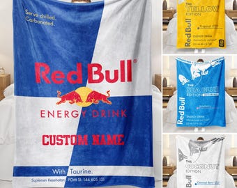 May include: A soft fleece blanket featuring a Red Bull energy drink design with a blue and white color scheme, the Red Bull logo, the text "Serve chilled. Carbonated.", "ENERGY DRINK", "CUSTOM NAME", "With Taurine.", and "Suplemen Kesehatan POM SI. 144 605 131".
