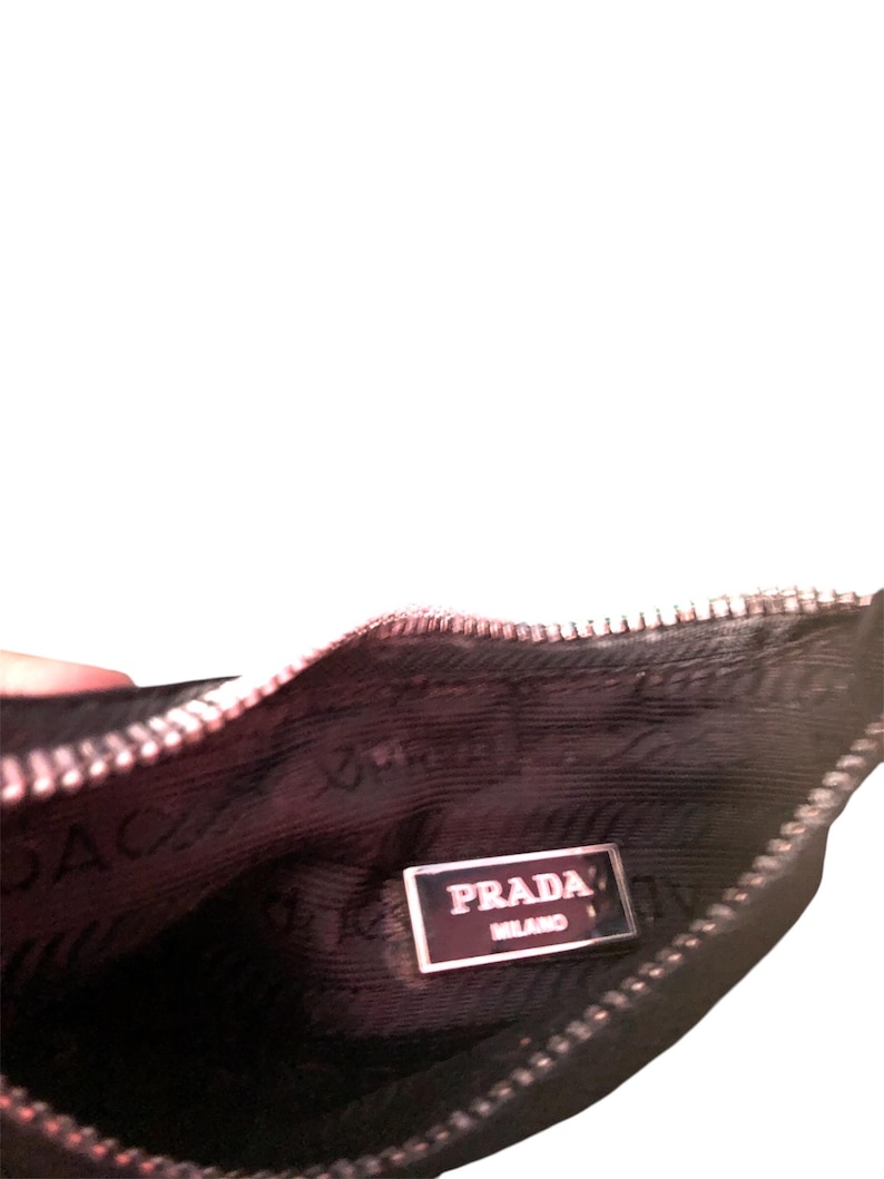 May include: Black zippered pouch with a Prada Milano label inside.