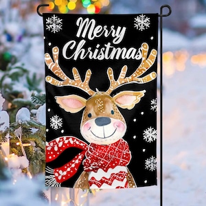 May include: A black Christmas garden flag with a white reindeer wearing a red and white scarf. The flag says "Merry Christmas" in white text.
