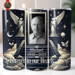 Könnte beinhalten: Ein schwarzer und weißer Becher mit einem Foto eines Mannes und dem Text "Michael 1932-2025 Forever in our Hearts". Der Becher hat ein Design mit Engeln und Sternen auf einem dunklen Hintergrund.