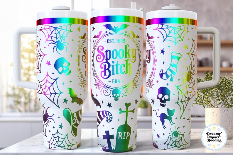May include: White tumbler with a Halloween theme, featuring a rainbow gradient rim and handle. The design includes spiders, cobwebs, bats, skulls, and the text "Spooky Bitch - ERA" in a colorful, circular frame. The tumbler has a white lid.