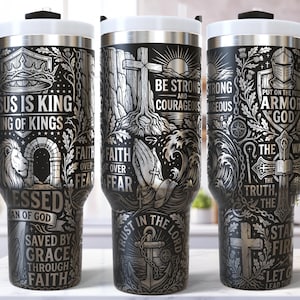 May include: Three stainless steel travel mugs with black handles and lids. Each mug features intricate silver engravings with religious themes, including crosses, lions, and inspirational text like "Jesus is King" and "Be Strong."