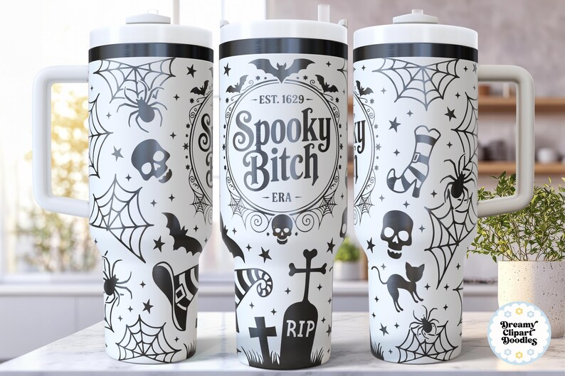 May include: White tumbler with a black Halloween-themed design. The design includes spiderwebs, spiders, bats, skulls, and the text "Spooky Bitch". The tumbler has a white handle and lid, perfect for spooky season.
