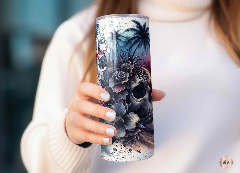 May include: A white stainless steel tumbler with a colorful design featuring a skull with flowers and palm trees.