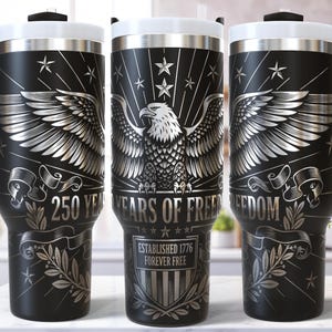 May include: Black travel mug with a white lid and handle, featuring a silver eagle design with the text "250 YEARS OF FREEDOM" and "ESTABLISHED 1776 FOREVER FREE".