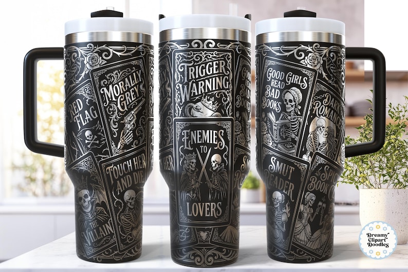 May include: Black travel mug with a white lid and handle, featuring a gothic design. The mug is adorned with illustrations of skulls, playing cards, and phrases like "Trigger Warning" and "Good Girls Read Bad Books."