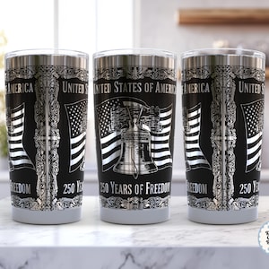 May include: Three black stainless steel tumblers with a silver design. Each tumbler features the American flag, the Liberty Bell, and the text "UNITED STATES OF AMERICA" and "250 YEARS OF FREEDOM".