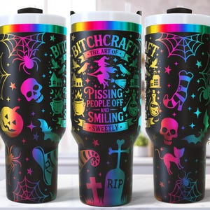 May include: Three black travel mugs with white lids and black handles. Each mug features a colorful Halloween-themed design with spiders, skulls, bats, and the text "BITCHCRAFT". The mugs are decorated with a rainbow gradient.