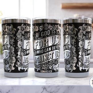 Peut inclure: Trois gobelets en acier inoxydable avec des fonds noirs et des motifs floraux et de défilement argentés. Le texte "IF GOD IS FOR US, WHO CAN BE AGAINST US" est affiché sur le devant de chaque gobelet. Le texte "ROMANS 8:31" est également visible.