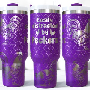 May include: A purple travel mug with a white lid and handle. The mug features a silver rooster design and the text "Easily distracted by Peckers". The design is repeated around the mug.