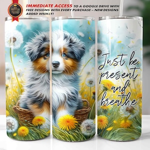 May include: A white tumbler with a design featuring a puppy in a basket surrounded by dandelions and the text "Just be present and breathe." The tumbler also has the text "IMMEDIATE ACCESS TO A GOOGLE DRIVE WITH FREE DESIGNS WITH EVERY PURCHASE - NEW DESIGNS ADDED WEEKLY!"