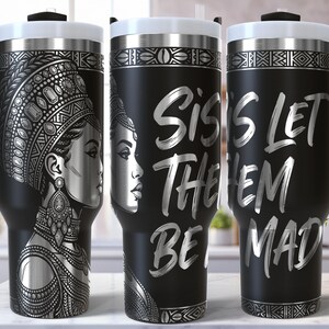 May include: Black travel tumbler with a silver design featuring a woman's profile and the text "Siss Let Them Be Mad." The tumbler has a black handle, a white lid, and a silver rim. The design is repeated on all three tumblers.