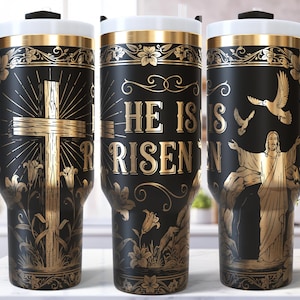 Könnte beinhalten: Schwarze Reisebecher mit goldenen religiösen Designs. Auf einem Becher ist ein Kreuz abgebildet, ein anderer Schriftzug lautet „Er ist auferstanden“, und der dritte zeigt Jesus mit Tauben. Jeder Becher hat einen schwarzen Griff, einen weißen Deckel und goldene Akzente.
