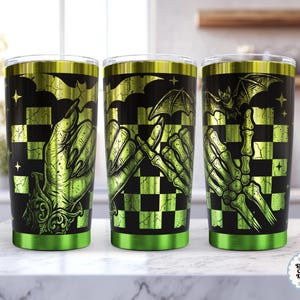 Può includere: Tre bicchieri in acciaio inossidabile con uno sfondo a scacchi nero e verde lime. Il design presenta un'illustrazione dettagliata di una mano umana e una mano scheletrica che fanno una promessa, accentuata da pipistrelli, stelle e polsini decorati.