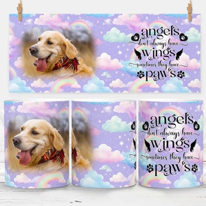 Może przedstawiać: Biały ceramiczny kubek i prostokątny nadruk z psem Golden Retriever z czerwoną szarfą, na tle pastelowego nieba z tęczami i chmurami. Kubek i nadruk mają napis "angels don't always have wings, sometimes they have paws."