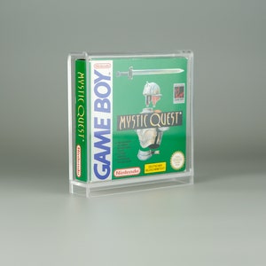 Könnte beinhalten: Eine transparente Acryl-Vitrine mit einer Game Boy-Spielkassette. Die Kassette zeigt das Spiel "Mystic Quest" mit grünem Hintergrund und einer Ritterillustration. Das Game Boy-Logo ist auf der Seite sichtbar.