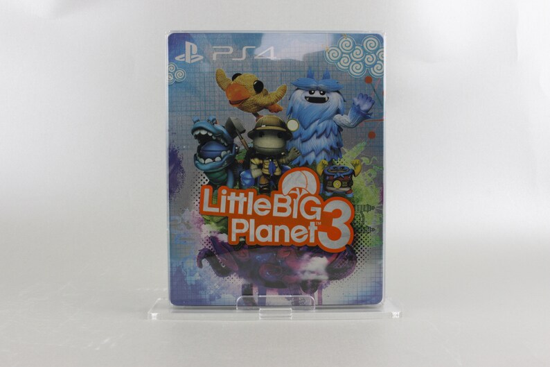 May include: A blue, orange, and white video game case for LittleBigPlanet 3 for the Playstation 4. The case features a blue, furry monster, a green, dinosaur-like creature, a yellow bird, and a small, brown character with a red hat.