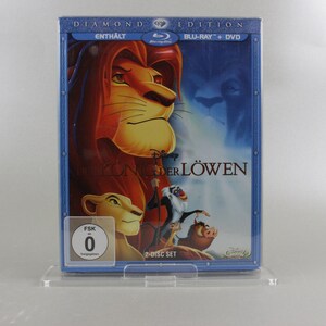 May include: A blue DVD case with a 2-disc set of the movie "The Lion King" in a diamond edition. The front of the case features a picture of Simba, the lion, with the text "DIAMOND EDITION" and "BLU-RAY + DVD" in white. The case also includes a FSK rating of 0.