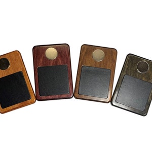 May include: Four wooden coasters with a black felt top and a silver metal accent. The coasters are in different wood tones: brown, purple, green, and a lighter brown.