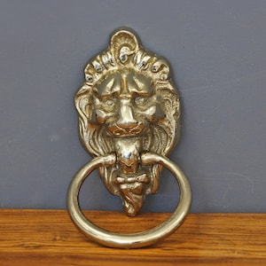 Metalowa kołatka do drzwi w kształcie głowy lwa, zabytkowa, zewnętrzna, biała metalowa dekoracja Lionhead, stylowy dodatek do drzwi, wyjątkowa niemiecka metalowa kołatka w kształcie głowy lwa.