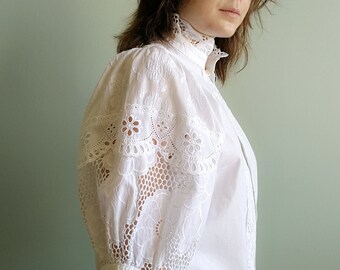 White cotton folk blouse with operated puffed sleeves with sangallo lace and operated closure and collar