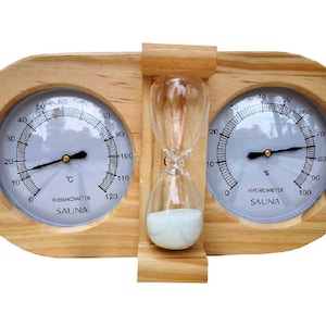 May include: A wooden sauna thermometer and hygrometer with an hourglass in the centre. The thermometer reads up to 120 degrees Celsius and the hygrometer reads up to 100%. The hourglass is filled with white sand.
