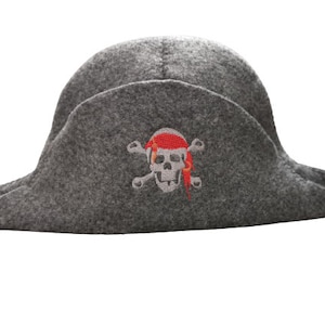 Könnte beinhalten: Ein grauer Filz-Piratenhut mit einem roten und weißen Totenkopf- und Knochen-Design.