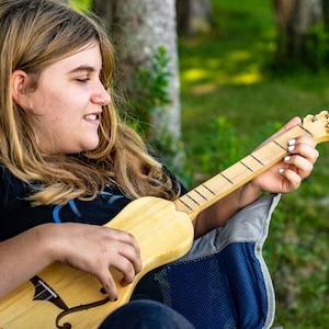 the Boondocker Maple + Spruce  Dulcitar 4 string Musical String Instrument. Small, lightweight, great for travel. Anyone can play!