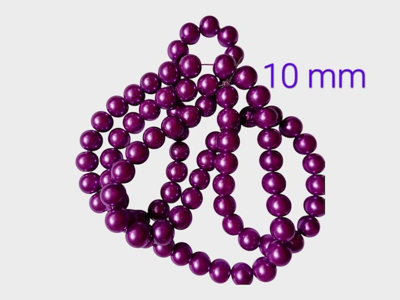 May include: A strand of deep purple beads, each 10 mm in diameter, arranged in a decorative pattern. The beads have a glossy finish and are strung together. The text "10 mm" is visible in the image.
