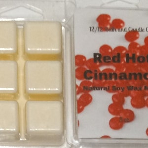 May include: Four wax melts in a clear plastic container. The wax melts are white and have a red hot cinnamon scent. The container has a label that says "Red Hot Cinnamon" and "Natural Soy Wax Melts".