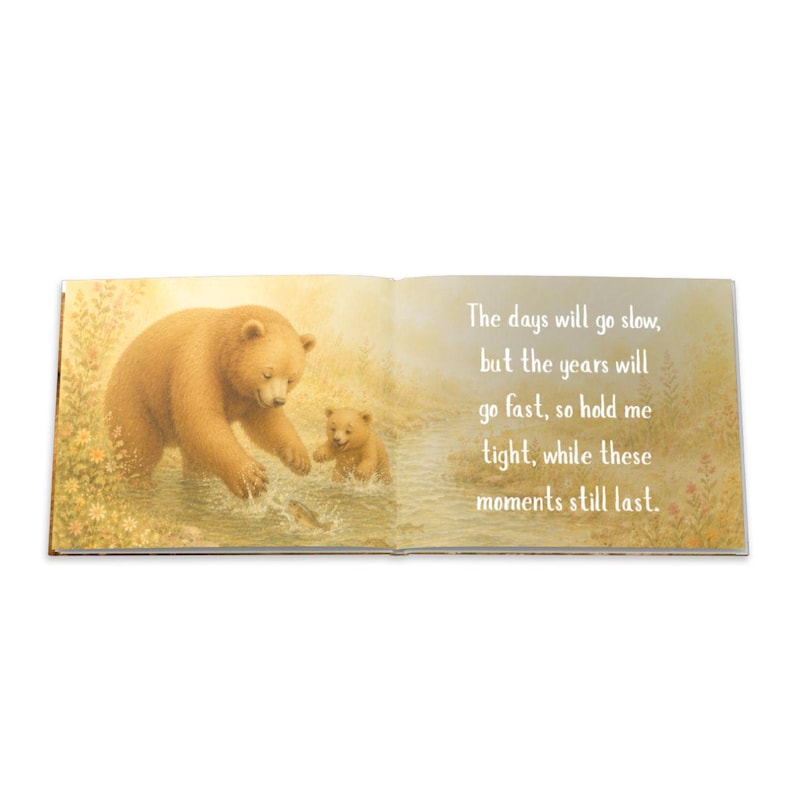 May include: An open book with a heartwarming illustration of a brown bear and a cub in a stream. The text reads, "The days will go slow, but the years will go fast, so hold me tight, while these moments still last."