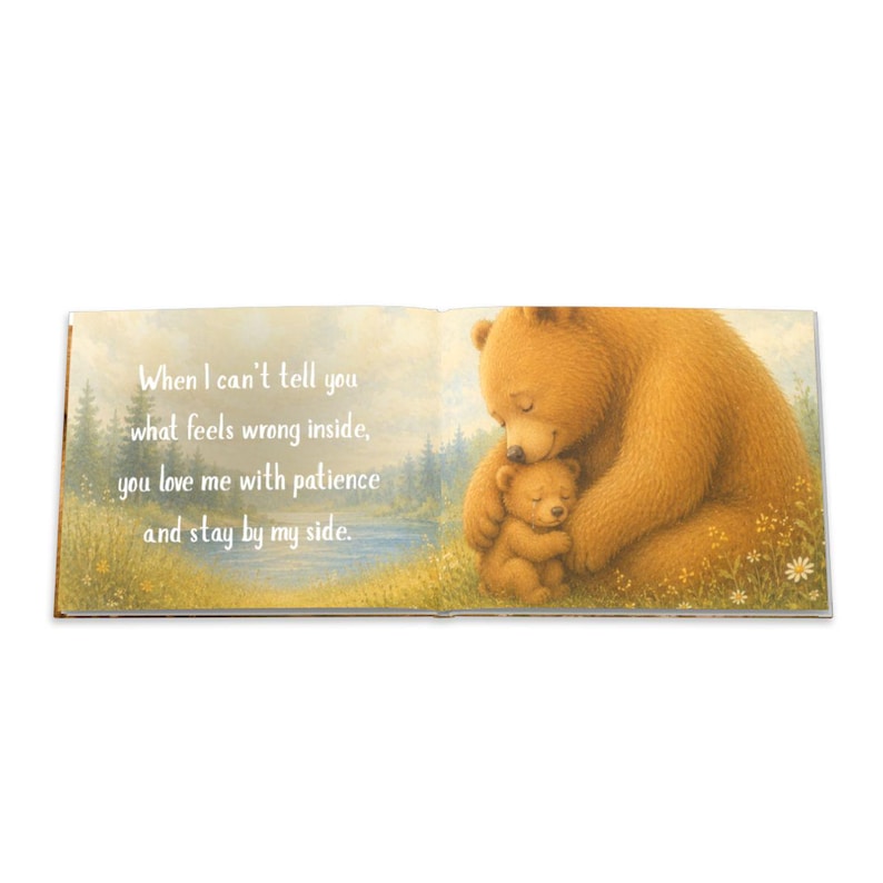 May include: An open book with a heartwarming illustration of two bears. A larger bear embraces a smaller bear, set against a backdrop of a serene landscape. Text on the left page reads: "When I can't tell you what feels wrong inside, you love me with patience and stay by my side."