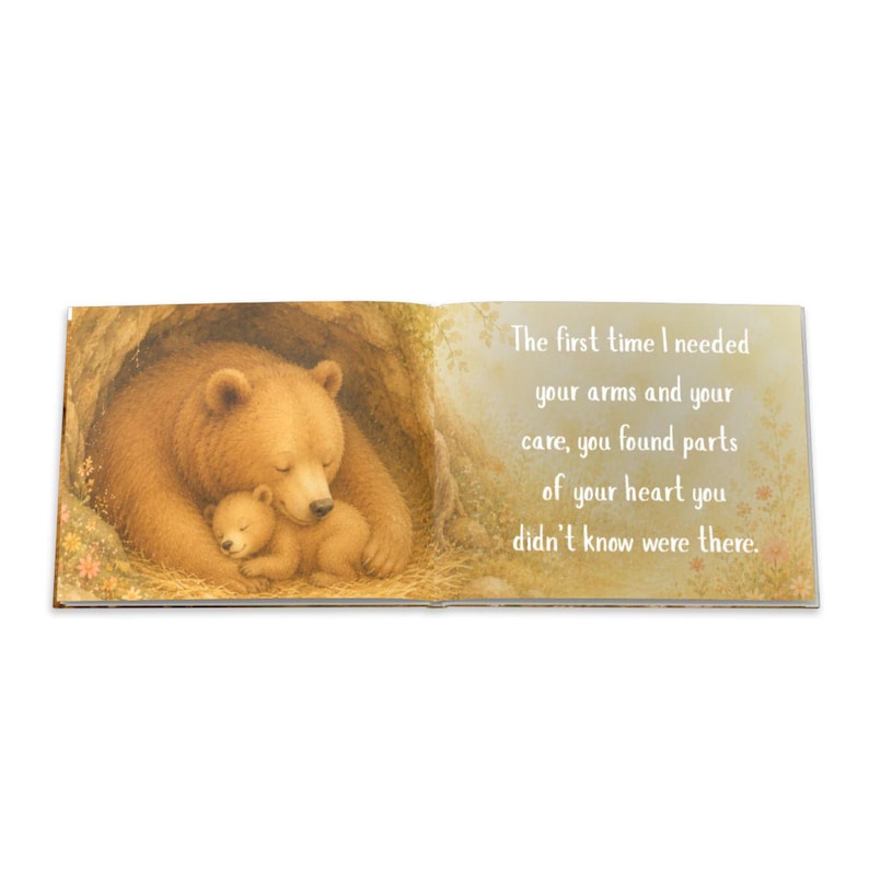 May include: An open book with a heartwarming illustration of a mother bear and cub nestled together in a cave. The text on the right page reads, "The first time I needed your arms and your care, you found parts of your heart you didn't know were there."