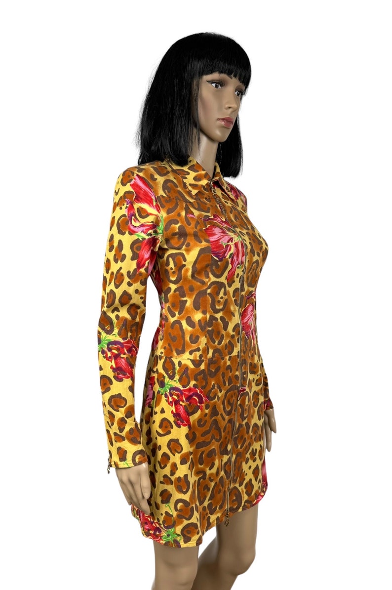 May include: A yellow, brown and red leopard print dress with long sleeves and a zip down the front.