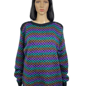 May include: A purple, green, and brown patterned sweater with a crew neck.
