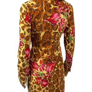 May include: A yellow, brown and red patterned dress with long sleeves and a zip closure. The dress features a leopard print and large red flowers.